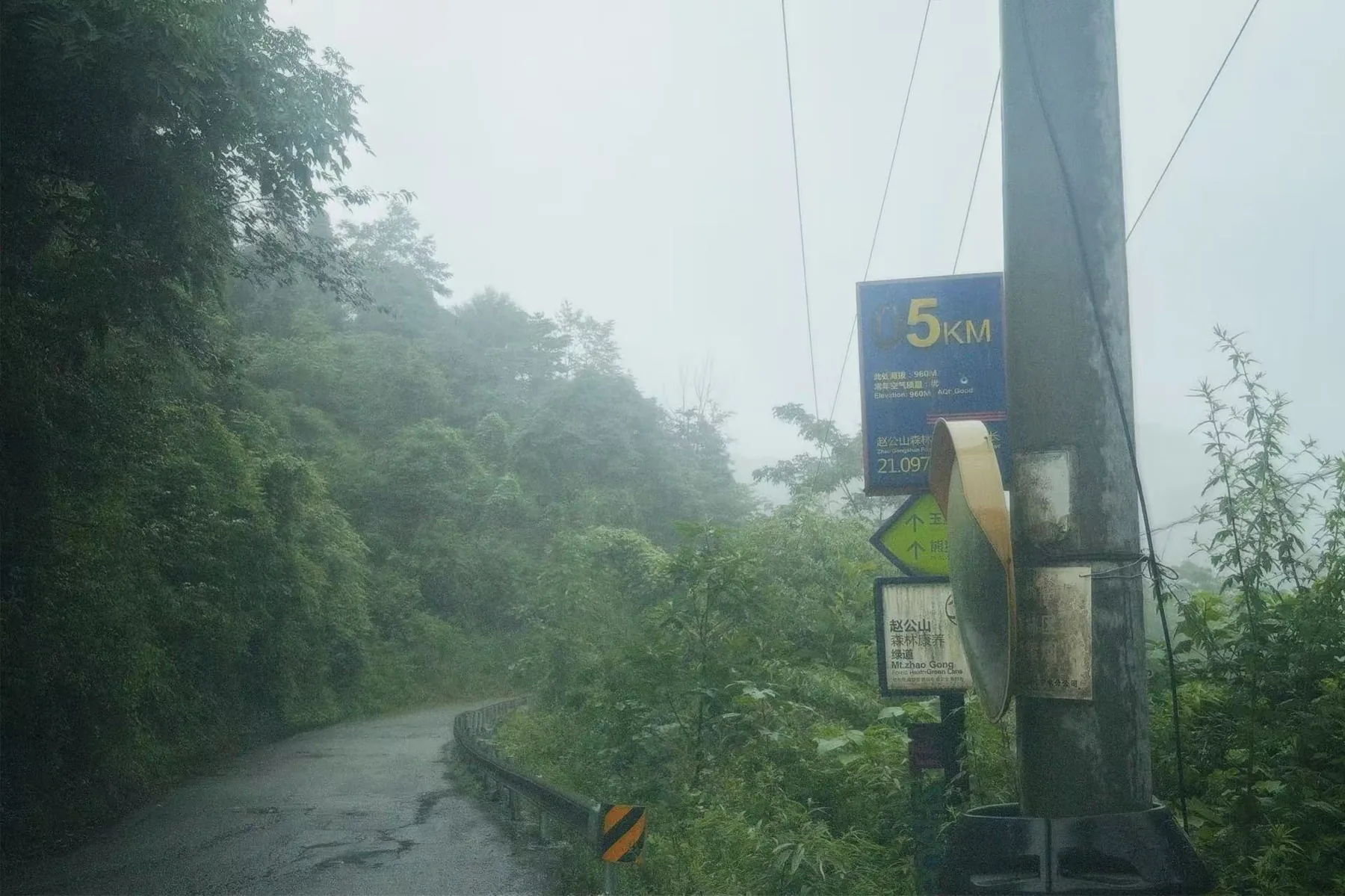 雾雨里的赵公山路牌，路边写着 5km。